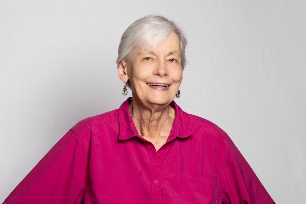 Carol B. Schwalbe, executive director for ODD Foundation, in a lavender blouse in front of a white backdrop.